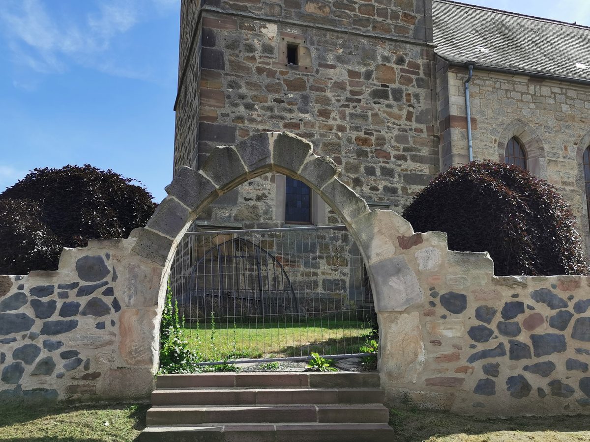 Spitzbogiges Mauerportal aus Sandstein in der Kirchhofmauer der Werkeler Kirche